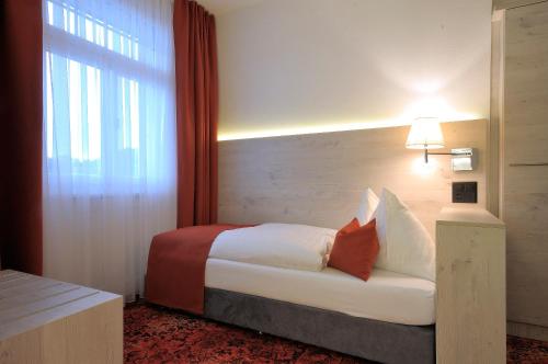 a hotel room with a bed with a window and a bed sidx sidx at Hotel Restaurant Bellevue au Lac in Thun