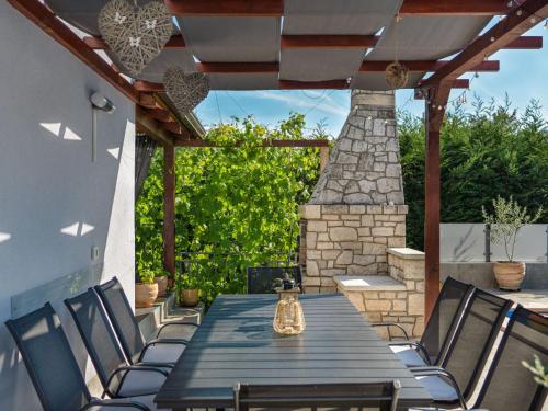 a table and chairs on a patio with a fireplace at Holiday Home Gabi by Interhome in Brtonigla