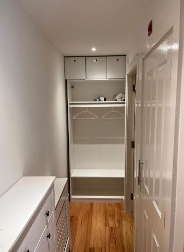 a walk in closet with white cabinets and wood floors at Chic Duplex w Rooftop Retreat in Dublin