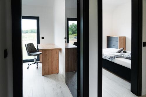a bedroom with a bed and a desk and a desk chair at Apartament 3 z ogródkiem in Sieniawa Żarska