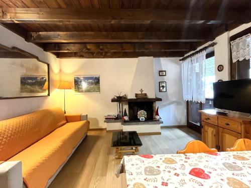 GiustinoにあるApartment Mansarda al Doss by Interhomeのリビングルーム(黄色のソファ、テレビ付)