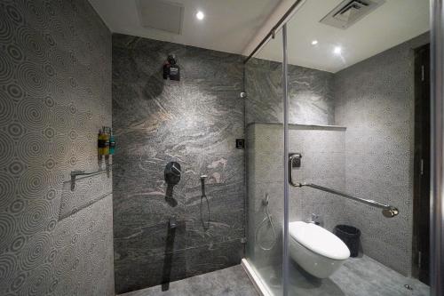 a bathroom with a shower with a toilet and a sink at Olive Hotel MG Road Dunsvirk Inn by Embassy Group in Bengaluru