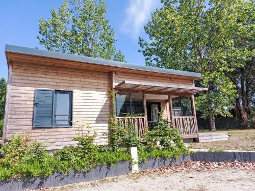 a tiny house with a porch and a window at Holiday Home Chalet moderne La Baule-Guérande by Interhome in Guérande