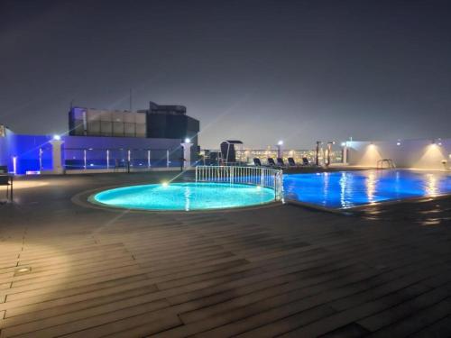 a swimming pool at night with blue lights at Dubai Silicon Oasis Holiday Homes in Dubai