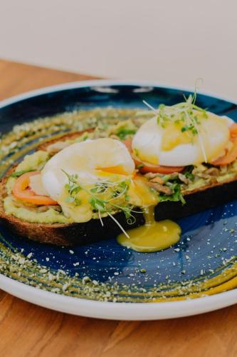 a blue plate with a sandwich with eggs on it at Sky Breeze in Unawatuna