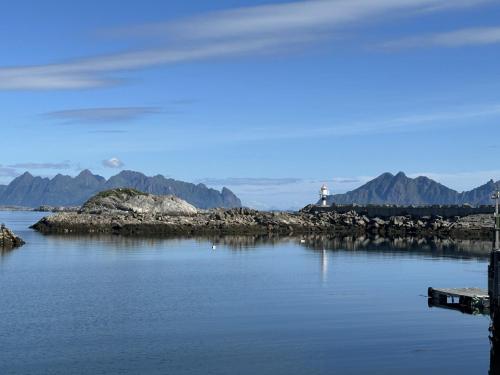 a lighthouse on an island in a body of water at Statsbuene i Kabelvåg in Kabelvåg