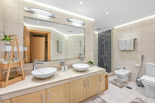 迪拜The Palm Jumeirah Shoreline Living l 3BR Elegant Resort Style Entire Home l Beach Access的带两个水槽、一个马桶和一面镜子的浴室