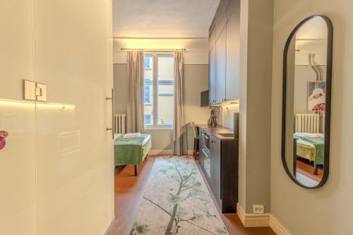 a small room with a mirror and a kitchen at The Apartments Company - The Sweet in Oslo