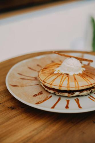 a plate of pancakes with whipped cream on a table at Sky Breeze in Unawatuna