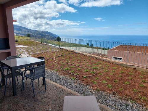 a patio with a table and chairs and the ocean at Casa Caipirinha in Prazeres