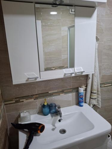 a bathroom sink with a mirror and a white sink at Apartman Taurus in Požarevac