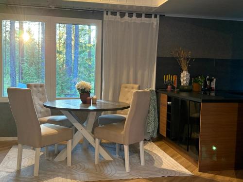 a dining room with a table and chairs and a window at Charmig stuga nära Dammsjön in Gustafs
