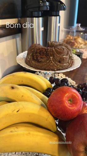 a bunch of bananas and apples and other fruits on a table at Pousada Ágape duplo in Chapada dos Guimarães