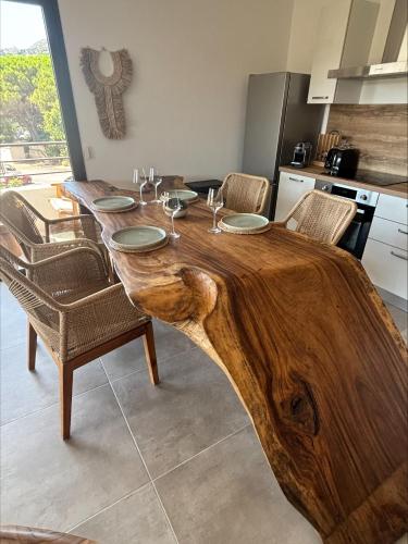 a wooden table with chairs and a table with a wooden tree stumpimateimateccess at A Isula Paradisu - Classé 4 étoiles in LʼÎle-Rousse