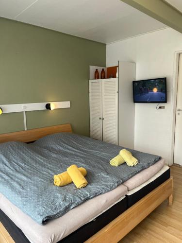 a bedroom with a bed with two yellow pillows at Døstrup Landevejskro & Motel in Skærbæk