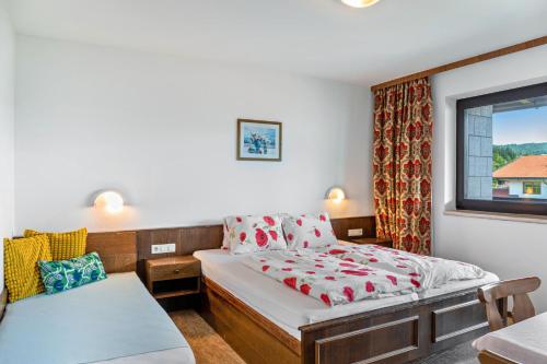 a small bedroom with a bed and a window at Pension Heidelberg in Hopfgarten im Brixental