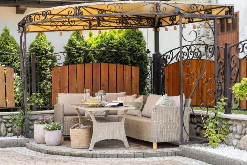 a patio with a couch and a table and chairs at Willa Podhalanka Jacuzzi & sauna - drewniany dom dla 20 osób in Biały Dunajec