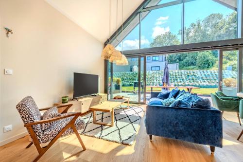 a living room with a couch and a table and chairs at Maison familiale proche mer - spa in Goulven