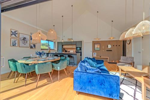 a living room with a blue couch and a table at Maison familiale proche mer - spa in Goulven