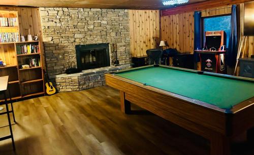 a pool table in a room with a fireplace at Alaska Getaway in Palmer