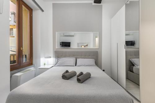 a bedroom with a bed with two slippers on it at White APT - Duomo - 6 posti in Milan