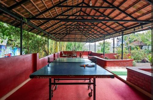 a large ping pong table in a pavilion with a table at Forest Haven in Batheri