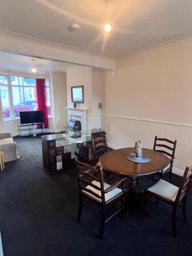 a living room with a table and chairs and a television at Grace House in Stockton-on-Tees