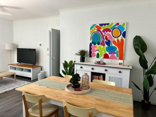 a dining room with a table and a painting on the wall at Stylish Townhouse in Kensington in Melbourne