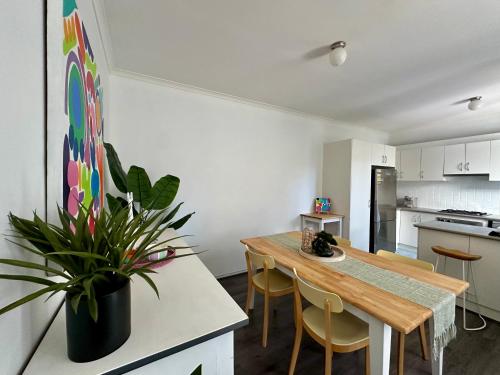 a kitchen with a wooden table and a dining room at Stylish Townhouse in Kensington in Melbourne