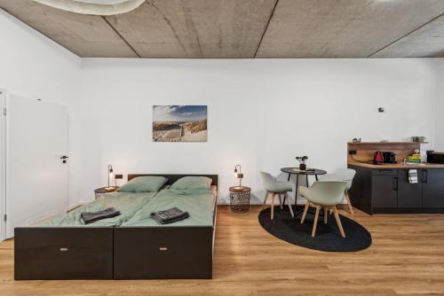 a bedroom with a bed and a table with chairs at Nordbrise by BohnApartments-Modernes Apartment-Zentrum Diepholz-Parken kostenfei in Diepholz