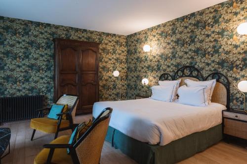 a bedroom with a large bed with floral wallpaper at Domaine Saint Clair - Le Donjon in Étretat