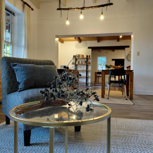 a living room with a glass table and a couch at Swellendam Country Lodge - Guest House - B&B in Swellendam