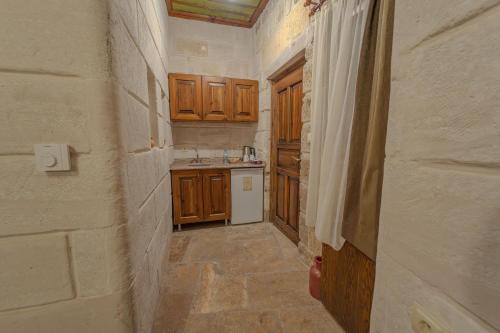 a small kitchen with wooden cabinets and a sink at Zara Cave Hotel in Goreme