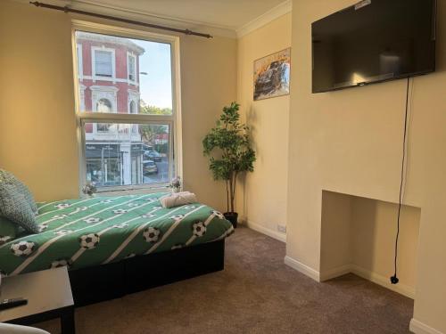 a bedroom with a bed and a tv and a window at Smart Junction in Norwood