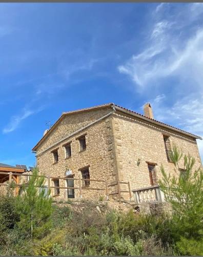 an old stone building with a blue sky in the background at Casa Rural Mas María in Horta de San Joan