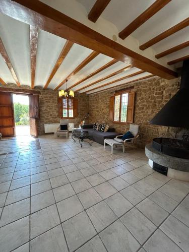 a large living room with a stone wall at Casa Rural Mas María in Horta de San Joan