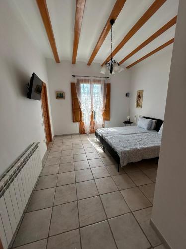 a bedroom with a bed and a window at Casa Rural Mas María in Horta de San Joan