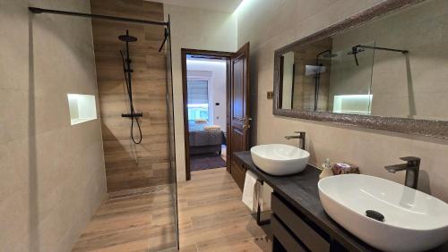 a bathroom with a sink and a mirror and a shower at Villa Marea in Opatija