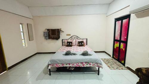 a bedroom with a bed with shoes on it at Capital O 91187 D'dusun Raudhah Chalet in Baling