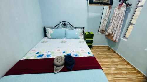 a small bedroom with a bed with blue walls at Capital O 91187 D'dusun Raudhah Chalet in Baling