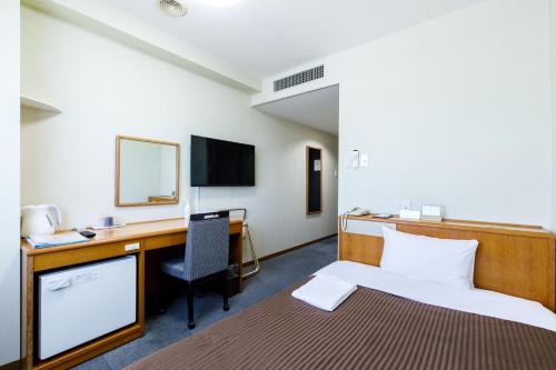 a hotel room with a bed and a desk and a computer at SAIDAIJI GRAND HOTEL - Vacation STAY 92824 in Okayama