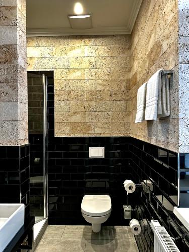 a black bathroom with a toilet and a sink at Designhotel Central Fulda in Fulda