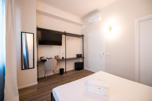 a room with a table and a television and a chair at Montebello Living in Ancona