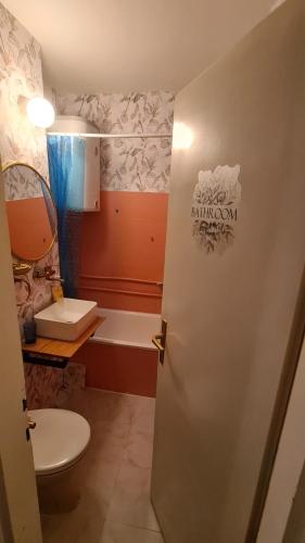 a bathroom with a toilet and a bath tub at Lovely apartment near NS Fair in Novi Sad