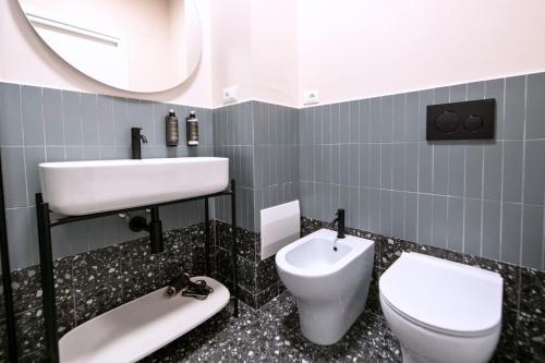 a bathroom with a sink and a toilet and a mirror at Montebello Living in Ancona