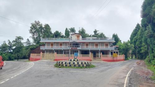 a large house sitting on the side of a road at Ess-PHLYNDA in Lāitlyngkot