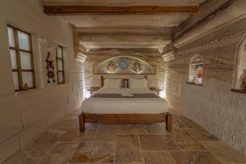 a bedroom with a bed in a stone wall at Zara Cave Hotel in Goreme
