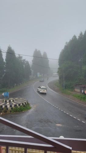 a car driving down a road in the rain at Ess-PHLYNDA in Lāitlyngkot