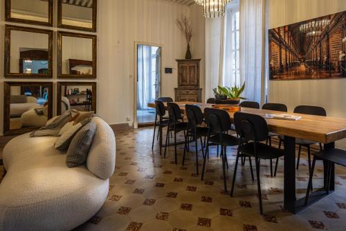 a living room with a couch and a table and chairs at La Chapelle sur la Sorgue in LʼIsle-sur-la-Sorgue
