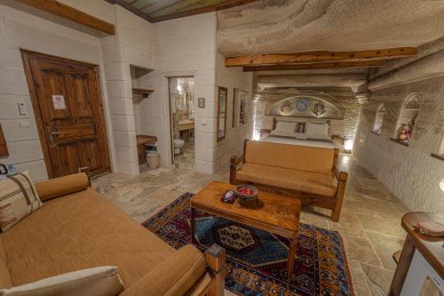 a bedroom with a bed and a couch and a table at Zara Cave Hotel in Goreme
